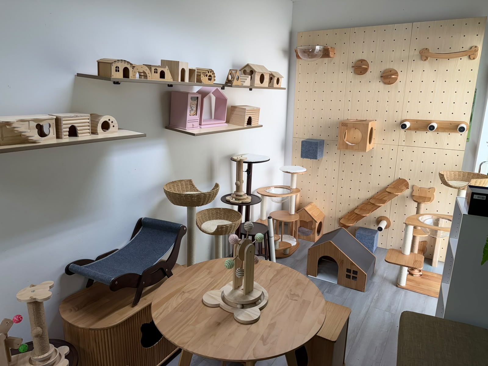Solid wood dog house, cat trees and wall climbing panel on display in the showroom
