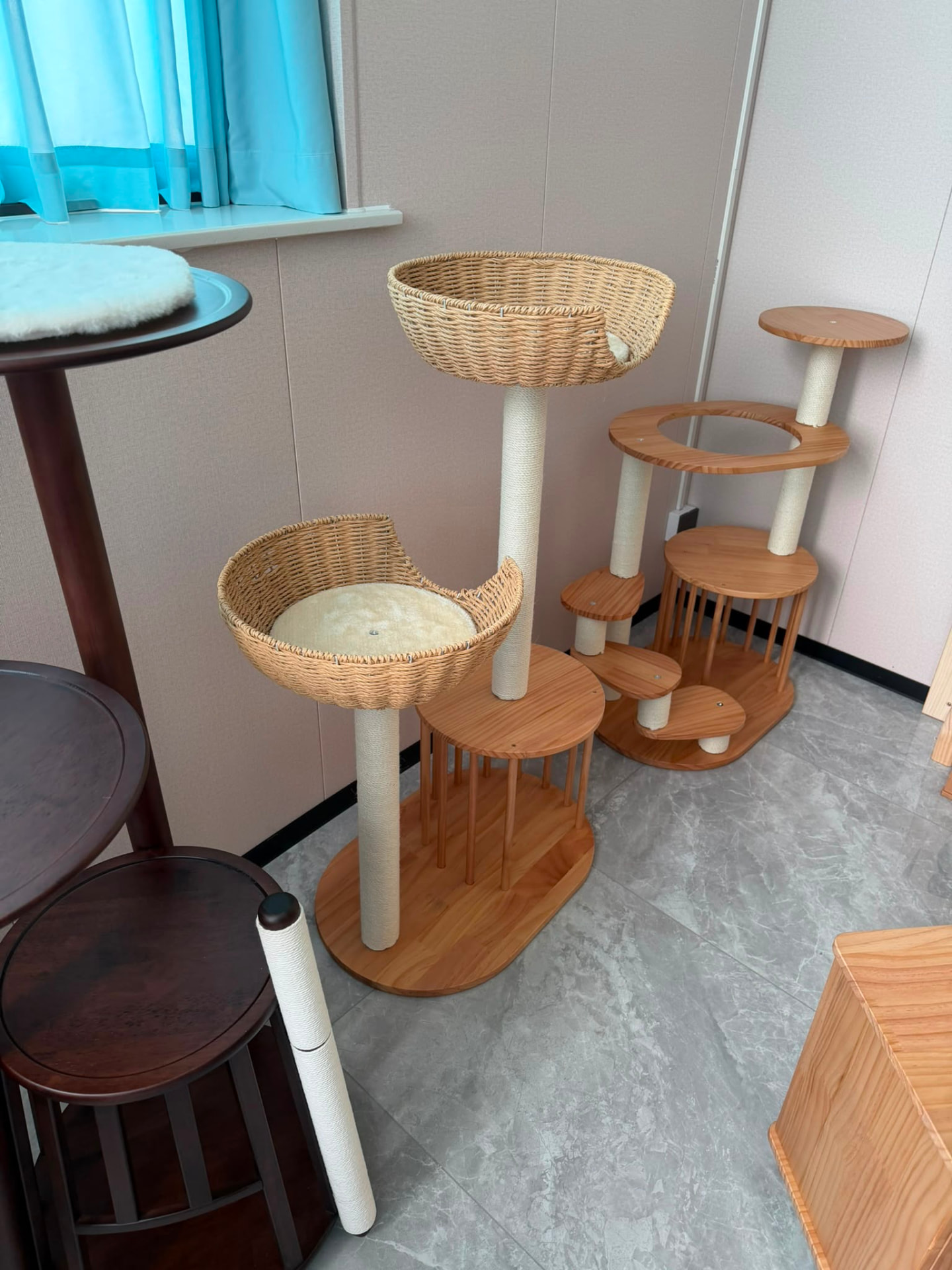 Solid wood cat trees with woven rattan basket beds, sisal-wrapped posts and tiered platforms