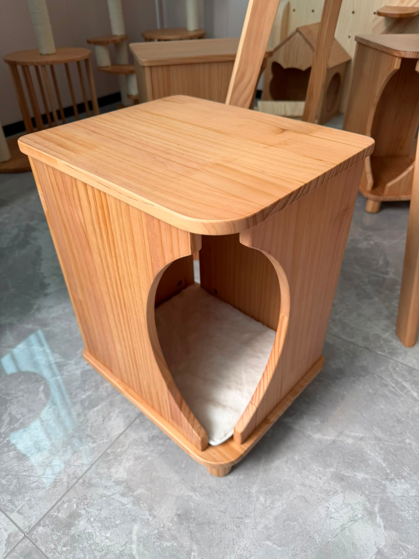 Solid wood cat den side table with cushioned interior and cat-shaped opening